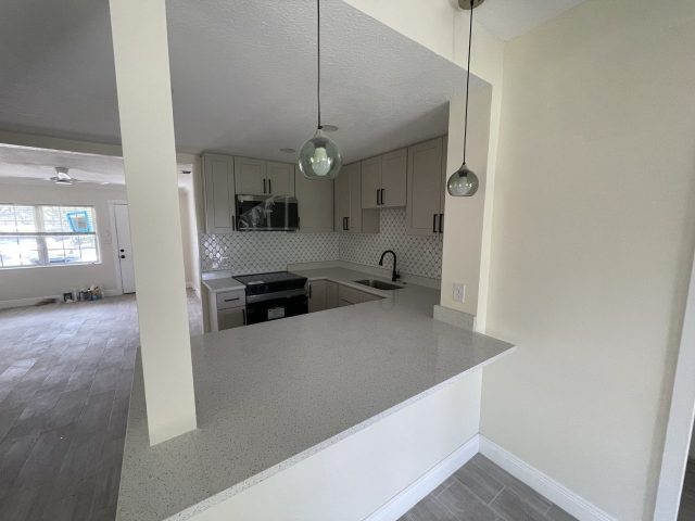Custom gray kitchen cabinetry with tile backsplash