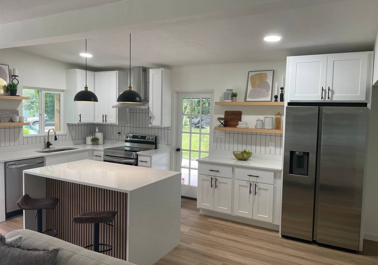 White custom kitchen cabinetry with a wood-slat island and pendant lighting